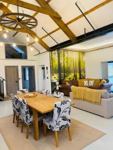 sala de estar con mesa de madera y sillas en Barnaby’s Barn, en Carmarthen