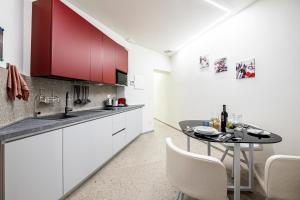 una cucina con mobili bianchi e un tavolo con sedie di Rifugio99 Oltrarno- Tra Arte e Giardini di Boboli a Firenze