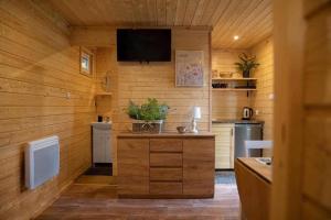 a kitchen with wooden walls and a flat screen tv at Stanica Wodna Swoboda in Augustów