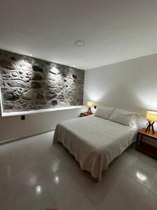 sypialnia z łóżkiem i kamienną ścianą w obiekcie Casa Cuauhtémoc 1 w mieście Puerto Vallarta