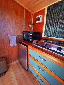 a kitchen with a stove and a refrigerator in a room at Petal Creek Farm in Tarakohe