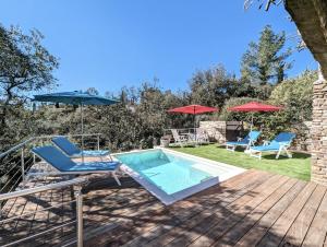 une terrasse avec une piscine, des chaises et des parasols dans l'établissement The Villa Capitou, à Fréjus