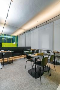 una clase con mesas y sillas y una pantalla de proyección en Elide Design Hotel, en Asís