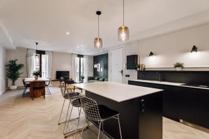 eine offene Küche und ein Wohnzimmer mit einem Tisch und Stühlen in der Unterkunft Lunalux Apartment in Barcelona