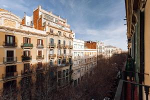 a row of buildings on a city street with trees at Lunalux Apartment in Barcelona