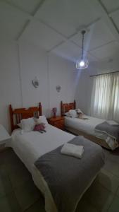 2 Betten in einem weißen Zimmer mit Klimaanlage in der Unterkunft Alhoa Halfway Stop in Gariepdam