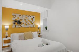 a bedroom with a white bed with a yellow wall at Central and Modern one bedroom flat in Oxford