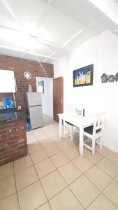 ein Wohnzimmer mit einem weißen Tisch und einem Kühlschrank in der Unterkunft Alhoa Halfway Stop in Gariepdam