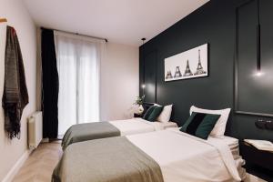 two beds in a room with black walls at Lunalux Apartment in Barcelona