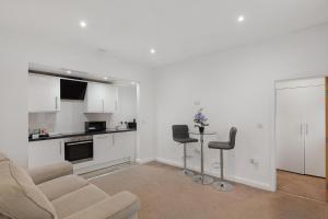 a white living room with a couch and two chairs at Central and Modern one bedroom flat in Oxford