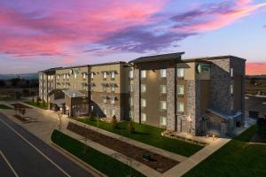 a rendering of a hotel at dusk at WoodSpring Suites Fort Collins in Fort Collins