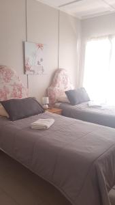 Dieses weiße Zimmer verfügt über 2 Betten und ein Fenster. in der Unterkunft Alhoa Halfway Stop in Gariepdam