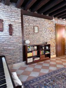 - un salon avec un mur en briques et un piano dans l'établissement Ca Giobbe, à Venise