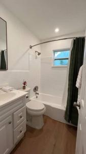 ein weißes Badezimmer mit Toilette, Badewanne und Fenster in der Unterkunft Morning Sunshine @Sailboat Bend in Fort Lauderdale + 22 Fotos