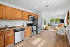 eine Küche mit Küchengeräten aus Edelstahl und Holzschränken in der Unterkunft Morning Sunshine @Sailboat Bend in Fort Lauderdale