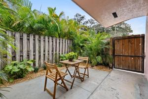 eine Terrasse mit Tisch und Stühlen und einem Zaun in der Unterkunft Morning Sunshine @Sailboat Bend in Fort Lauderdale