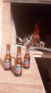tres botellas de cerveza sentadas junto a una chimenea en CASA RURAL G, en Elche de la Sierra