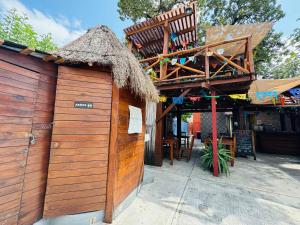 a building with a thatch roof and a restaurant at La Luz Hostal Cancun in Cancún