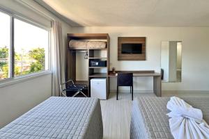 a bedroom with a bed and a desk and a table at Sky Premium Hotel Gramado - Ótima Localização in Gramado