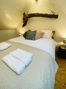 1 dormitorio con 2 camas y toallas blancas. en Barnaby’s Barn, en Carmarthen