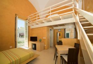 ガリポリにあるRelais Carlo V - Palazzo Storicoのベッドルーム1室(ロフトベッド1台付)、ダイニングルーム(テーブル付)