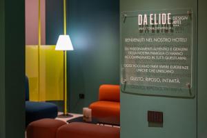 una sala de espera con una silla y una lámpara en Elide Design Hotel, en Asís