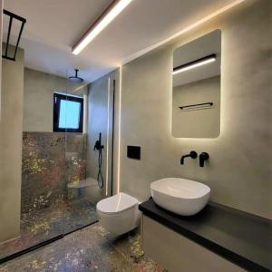 y baño con lavabo, aseo y ducha. en BlueMotion - ArteSuite, en Pireo