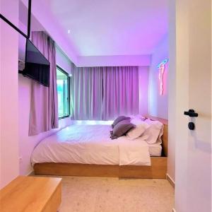 1 dormitorio con 1 cama grande con iluminación púrpura en BlueMotion - ArteSuite, en Pireo