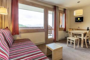 Mâcot La PlagneにあるRésidence Plagne Lauze - maeva Home - Appartement 2 Pièces 5 Personnes - Sélection MAE-3504のソファとテーブルのあるリビングルーム