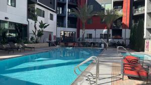 uma piscina com cadeiras e um edifício em Luxury furnished & Designed 2 Bedroom Part Hotel in Woodland Hills em Los Angeles