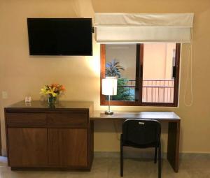 a desk with a lamp and a chair in a room at Pacific Inn hotel in Sayulita