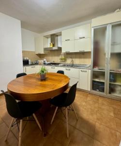 a large kitchen with a wooden table and chairs at L’armadio di Narnia in Alzano Lombardo +10 photos