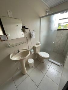 La salle de bains est pourvue d'un lavabo, de toilettes et d'une douche. dans l'établissement Pousada Folhas de Outono, à Canela