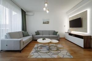 - un salon avec un canapé et une table dans l'établissement Apartman Square Trg Prijedor, à Prijedor