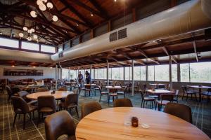 a restaurant with wooden tables and chairs and large windows at Wallaby Hotel in Gold Coast