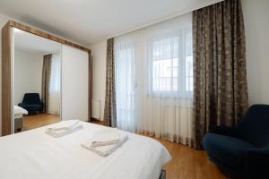 - une chambre d'hôtel avec un lit et un miroir dans l'établissement Apartman Square Trg Prijedor, à Prijedor