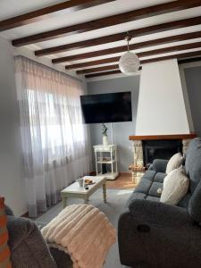 a living room with a couch and a tv at Villa San Miguel in Cudón