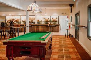 a pool table in a room with a bar at Wallaby Hotel in Gold Coast