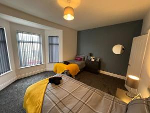 a bedroom with two beds and a cat laying on the bed at Brand new refurb 8 person house in Hull