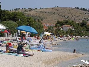 a group of people sitting on a beach at Apartments Govic in Zaboric +35 photos