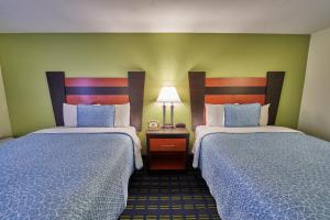 a hotel room with two beds and a lamp at The Mariner Resort Cape Cod by The Red Collection in West Yarmouth