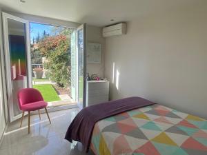 a bedroom with a bed and a chair and a window at The Villa Capitou in Fréjus