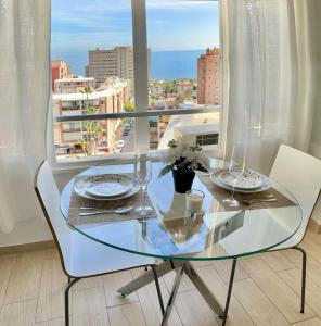 a glass table and chairs in a room with a window at VER855 - Playa y Centrico, Wifi, Fire Stick, Vistas al mar in Torremolinos