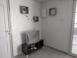 een hoek van een kamer met een tv aan de muur bij Studio avec vue sur la mer terrasse amenagee et wifi a Le Robert in Le Robert