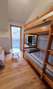 a bedroom with two bunk beds and a table at Apartment Niesenpoint in Albersdorf