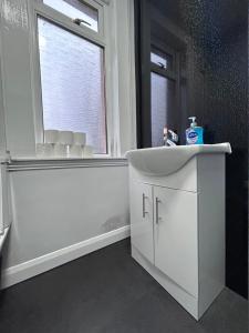 a bathroom with a white sink and a window at Urban Oasis:perfect stay in city in Edinburgh