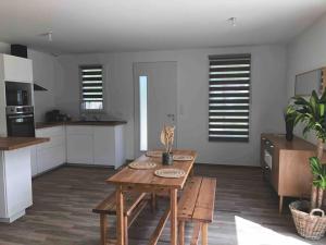 ein Wohnzimmer mit Tisch und Küche in der Unterkunft Jolie maison à 5 min de l'océan in Grayan-et-lʼHôpital + 7 Fotos