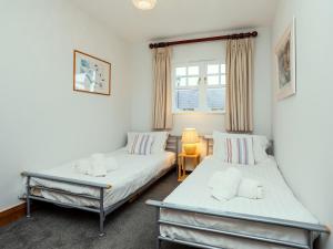 a bedroom with two beds and a window at Armstrong Cottages No30 in Bamburgh