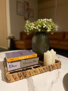 ein Tablett mit Büchern und eine Vase mit Blumen und Kerzen in der Unterkunft fun beach durrat alarous -فن بيتش درة العروس in Durrat Al-Arus