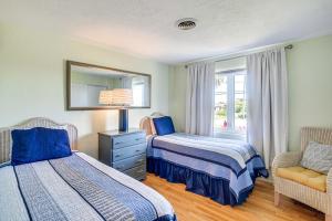 1 Schlafzimmer mit 2 Betten, einem Stuhl und einem Spiegel in der Unterkunft New Smyrna Beach Escape with Deck and Water Access in New Smyrna Beach